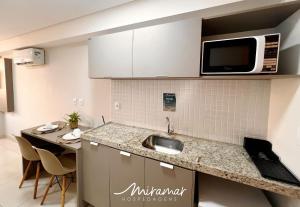 a kitchen with a sink and a microwave at Lindo flat no Manaíra Apart Hotel in João Pessoa