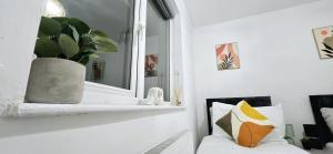 ein Wohnzimmer mit einem Spiegel und einer weißen Couch in der Unterkunft Corby Stay 2BR Work Trips & Family Friendly in Corby