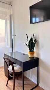 Un escritorio negro con una planta en maceta en la pared. en Terracota 2 Quartos Parque Cidade Pet Friendly, en Aveiro
