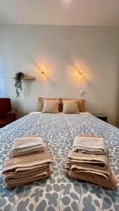 a bedroom with a bed with towels on it at Terracota 2 Quartos Parque Cidade Pet Friendly in Aveiro