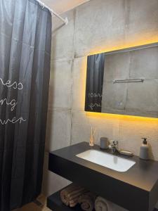 une salle de bain avec un lavabo et un miroir dans l'établissement warm&stylish apartment, à Shkodër