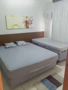 two twin beds in a room with a window at Hotel boulevard caldas novas in Caldas Novas