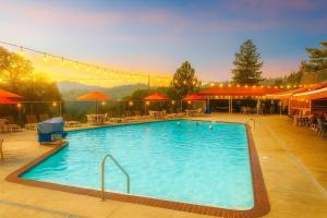 a large swimming pool with tables and chairs at Yosemite family getaway w lake, golf, horses, pool in Groveland