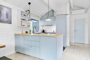 uma cozinha com paredes brancas e uma ilha azul em TV1554-Albaek-Jupitervej-4 em Ålbæk mais 17 fotografias