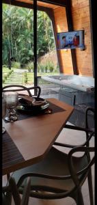 a wooden table with chairs and a television on a wall at Chalé Valentina com Hidro - oktoberfest in Blumenau