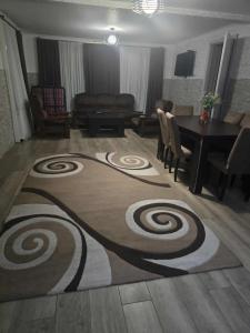 a living room with a table and a spiral rug at Guest House KATO in Poti