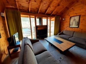 a living room with a couch and a coffee table at Casa de campo en Pilolil Sobre el Río alumine in Pilolil