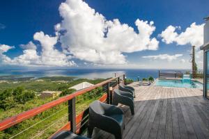 a balcony with chairs and a swimming pool at Villa de luxe vue exceptionnelle - MQDI92 10p in Le Diamant