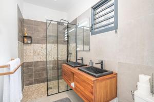 a bathroom with a sink and a glass shower at Villa de luxe vue exceptionnelle - MQDI92 10p in Le Diamant +27 photos