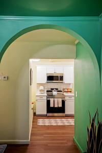 eine Küche mit einem Herd und einer grünen Wand in der Unterkunft NEW! The Spoonbill House - 2 Kings 1 Full, 10 Minutes to Downtown, 10 minutes to Airport in Charleston
