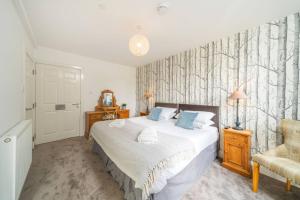 a bedroom with a bed and a chair at Taypark Garden View Apartment in Dundee