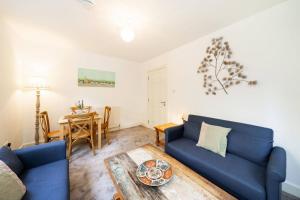 a living room with a blue couch and a table at Taypark Garden View Apartment in Dundee +31 photos