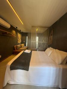 Un dormitorio con una gran cama blanca y un sofá. en Manatee C101 Patacho Porto de Pedras, en Porto de Pedras