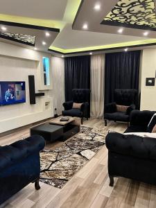 a living room with chairs and a couch and a tv at الزمالك in Cairo
