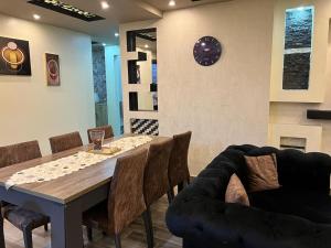 a dining room with a table and chairs and a clock at الزمالك in Cairo