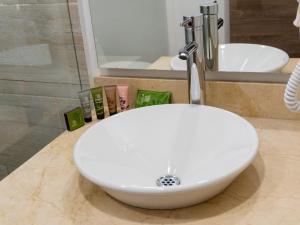a white sink in a bathroom with a shower at Hotel Molinos Plaza in Medellín