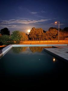 une piscine d'eau dans un parc la nuit dans l'établissement Cabañas Agapanthus Las Marias, à Tandil