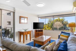 a living room with a couch and a tv at Bellardoo Holiday Apartments in Mooloolaba