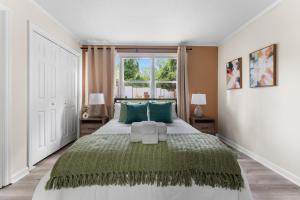 een slaapkamer met een groot bed met groene kussens bij Luxury 4BR Pool Jacuzzi Arcade USC Ft Jackson in Columbia +44 foto's