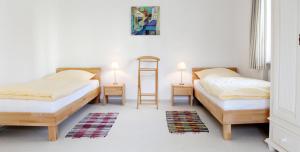 2 Betten in einem Zimmer mit 2 Tischen und 2 Lampen in der Unterkunft Ferienwohnung Zum Bäckersepp in Neuschönau