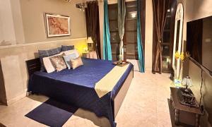 a bedroom with a blue bed in a room at Kaps Villa in Bhundsi +12 photos