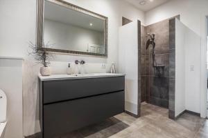 une salle de bain avec un lavabo et une douche avec un miroir dans l'établissement TV1512-Frederikshavn-Saltebakken-50-A, à Frederikshavn 31 autres photos