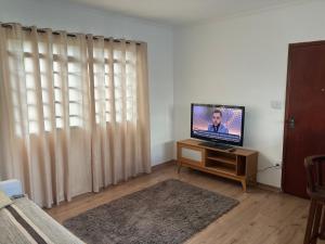 a living room with a flat screen tv on a table at Panamá 90 - 22 in Poços de Caldas