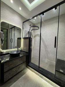 ein Badezimmer mit Waschbecken und Glasdusche in der Unterkunft EMPIRE-K Homes -Khalid's Villa in New cairo