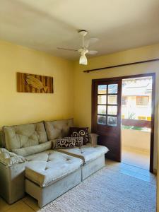 a living room with a couch and a ceiling fan at Apartamento Em frente a praia - Piscina condomínio América Praia, acesso privativo para a praia in Porto Seguro