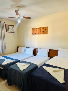 three beds in a room with a ceiling at Apartamento Em frente a praia - Piscina condomínio América Praia, acesso privativo para a praia in Porto Seguro