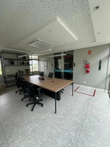 un bureau avec une grande table et des chaises en bois dans l'établissement Flat no Paraíso da praia do Cupe - Porto de Galinhas, à Porto de Galinhas 35 autres photos