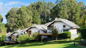 an image of a house with trees in the background at Pousada Villa Monte Verde in Monte Verde