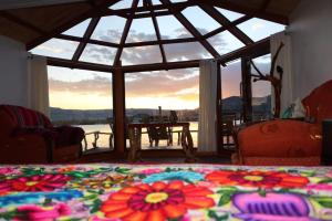 普诺Urosflotantelodge的一间有大窗户的房间,还有一张摆满鲜花的床