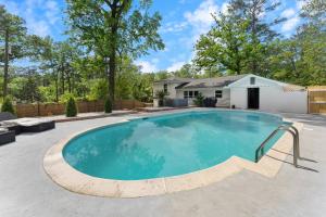 een zwembad in een tuin met een huis bij Luxury 4BR Pool Jacuzzi Arcade USC Ft Jackson in Columbia