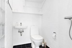 une salle de bain blanche avec toilettes et lavabo dans l'établissement TV1274-Bindslev-Tannisbugtvej-49-D-Nr-10, à Bindslev