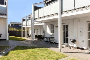 - une terrasse dans un bâtiment blanc avec une table et des chaises dans l'établissement TV1274-Bindslev-Tannisbugtvej-49-D-Nr-10, à Bindslev