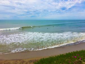 a beach with people surfing in the ocean at Chapa Surfhaus in Colonia Chapadmalal