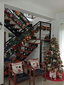 a christmas tree in a living room with a spiral staircase at Framelyn's Suites in Breezy Tagaytay in Tagaytay