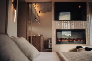 サンティリャーナ・デル・マルにあるNiditas PREMIUM SUITES & SPAのリビングルーム(暖炉、テレビ付)