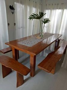 a wooden table with a potted plant and two benches at Framelyn's Suites in Breezy Tagaytay in Tagaytay +24 photos