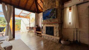 a living room with a fireplace and a tv at Pousada Villa Monte Verde in Monte Verde