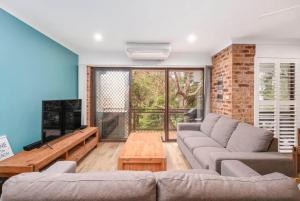 un soggiorno con un divano e una TV di 'Bay Parklands' - Coastal Resort Experience a Nelson Bay