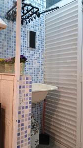 a bathroom with a sink and blue tiled walls at Kitnet tranquila e aconchegante in Ribeirão Pires