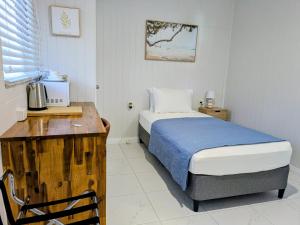 a bedroom with a bed and a desk with a microwave at Central Private Bedroom & Ensuite - City & Strand Beach Location in Townsville