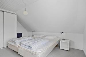 a white bedroom with a large bed with two pillows at TV1405-Skagen-Skomagergangen-5 in Skagen
