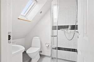 a white bathroom with a toilet and a shower at TV1405-Skagen-Skomagergangen-5 in Skagen +30 photos
