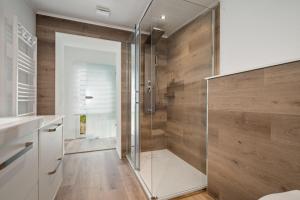 a glass shower in a bathroom with wooden walls at Ferienhaus-Kira in Rechlin +15 photos