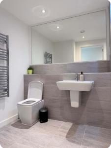 a bathroom with a sink and a toilet and a mirror at Modern and Stunning 1 Bed near Old Trafford and City Centre in Manchester