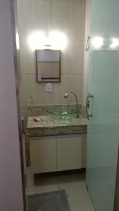 a bathroom with a sink and a mirror at Flats & Suítes do Lago in Guapé +11 photos