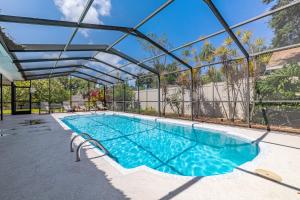 an indoor swimming pool with a glass roof at Stylish Home near Anna Maria Island Beaches - Heated Pool - Oasis in Bradenton